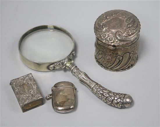 A silver handled magnifying glass, a silver trinket box, silver match box holder and silver vesta case.